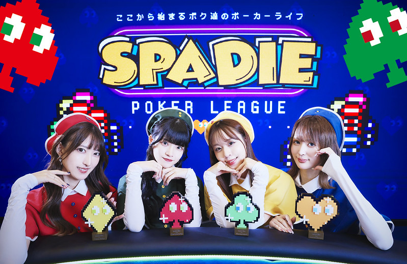 かわいい4スートのトロフィーと後ろに映るコンパニオンたち。